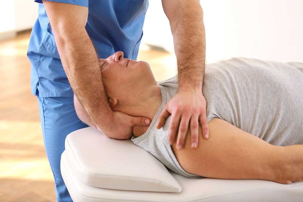 A chiropractor assessing a young athlete’s posture during a sports exam.