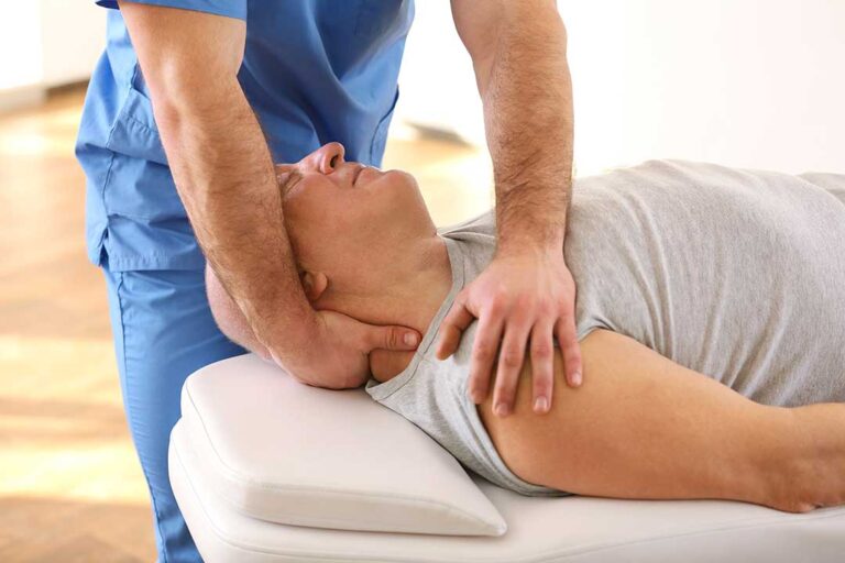 A chiropractor assessing a young athlete’s posture during a sports exam.