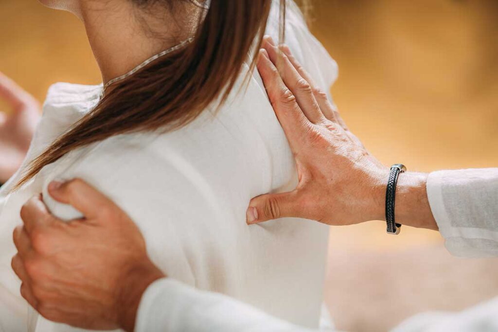 Person resting a sore thumb while holding a smartphone beside a supportive wrist pillow.